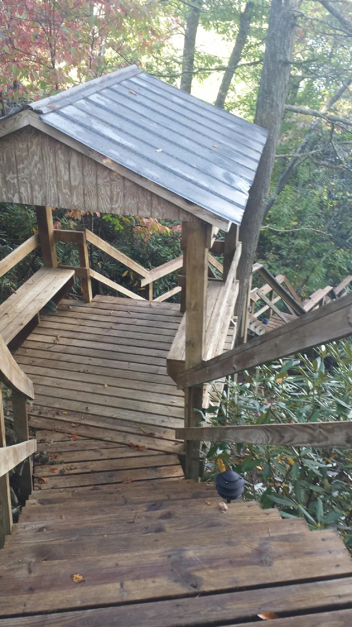 Metal roofed shelter over wooden steps on a wooded walkway — Skylight Repair & Installation work by our crew in Dedham