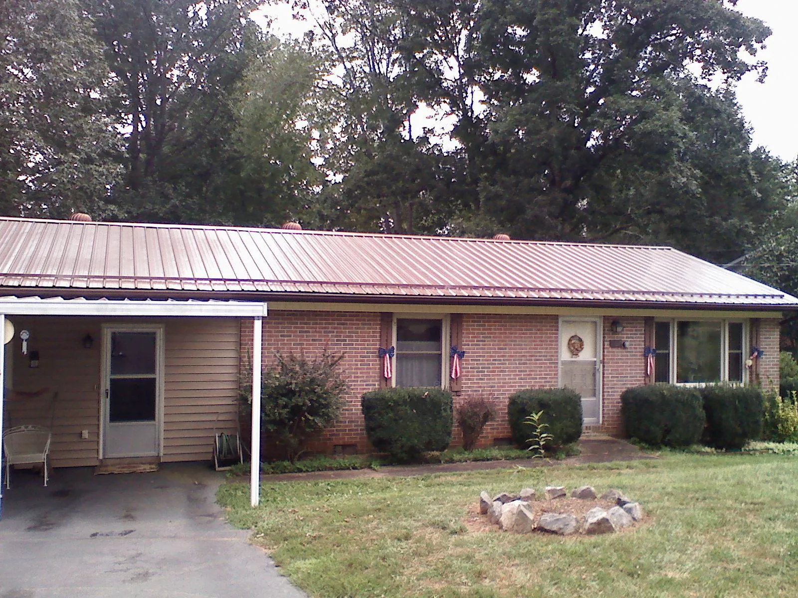 Bronze metal roof and carport on a brick ranch home — Roof Repair work by our crew in Dedham
